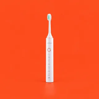AdvaSonic, the slim white ultrasonic toothbrush with a head fitted, on a vermilion background