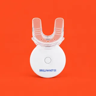 BrilliWhite, the white round LED unit with its clear U shaped mouthpiece upright, front on, on a vermilion background