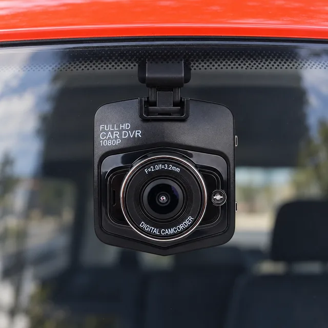 Nærbillede af fronten på det sorte DashSentry-bilkamera bag en forrude, med det runde objektiv og ordene FULL HD CAR DVR 1080P