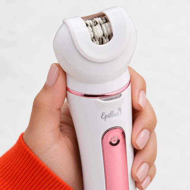 A close view of the Epillax epilator head and its rows of metal tweezer discs, the handle in a hand