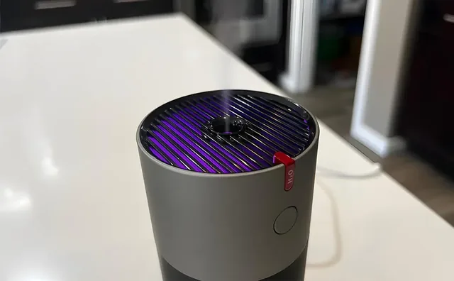 The top of the EvenBreeze on a white counter, its slotted grille lit by the mood light, the H2O tab and the round button below the rim
