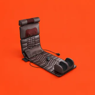 HarmonyMat Pro, the dark brown quilted massage mat with its back raised like a lounger: the neck roll and head pillow at the top, the small cushion with its pump bulb, the wired controller and the foot massager at the foot end, on a vermilion background