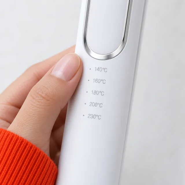 A fingertip beside the five temperature marks on the arm of the white HeatBliss, 140°C at the top and 230°C at the bottom