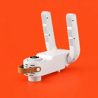 HeatTread, the white electric shoe dryer: two upright perforated arms on a flat body, a round dial with a black readout and a tan strap at the left end, on a vermilion background