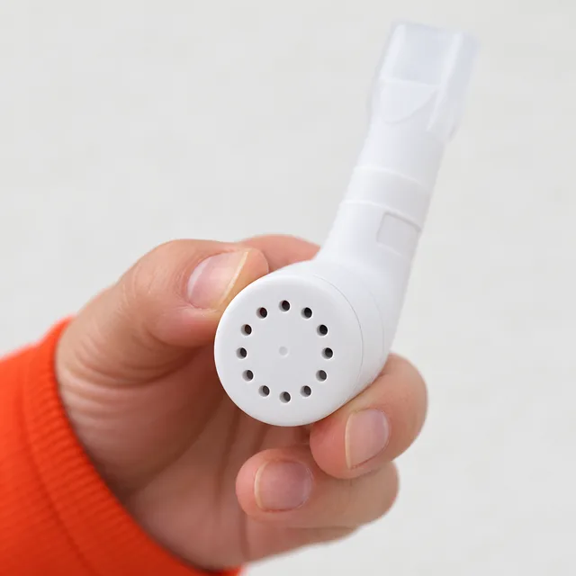 Fingers holding the white RespiraFix by its round cap, the ring of small holes toward the camera
