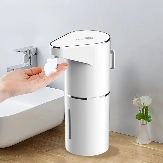 A hand, palm up, under the spout of the SensorFresh, a puff of soap on the fingers