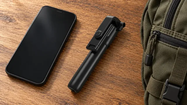 La SnapScope repliée en un bâton noir compact sur une table en bois, à côté d’un téléphone et d’un sac à dos olive