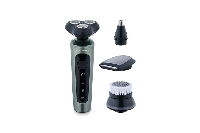 The dark green VoltGroom shaver standing upright beside its conical trimmer, foil styler and brush heads, on white