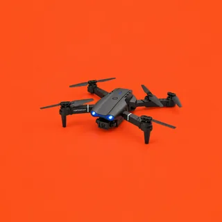 VortexScout, el dron plegable gris oscuro con sus cuatro brazos y hélices desplegados, sus dos luces delanteras azules encendidas y la cámara bajo el morro, sobre fondo bermellón
